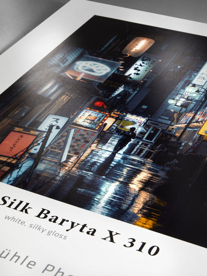 Framed photograph of a city street at night with reflective wet pavement, displayed on a Silk Baryta X 310 paper.