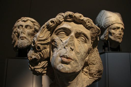 Close-up of carved stone faces in dramatic low light.