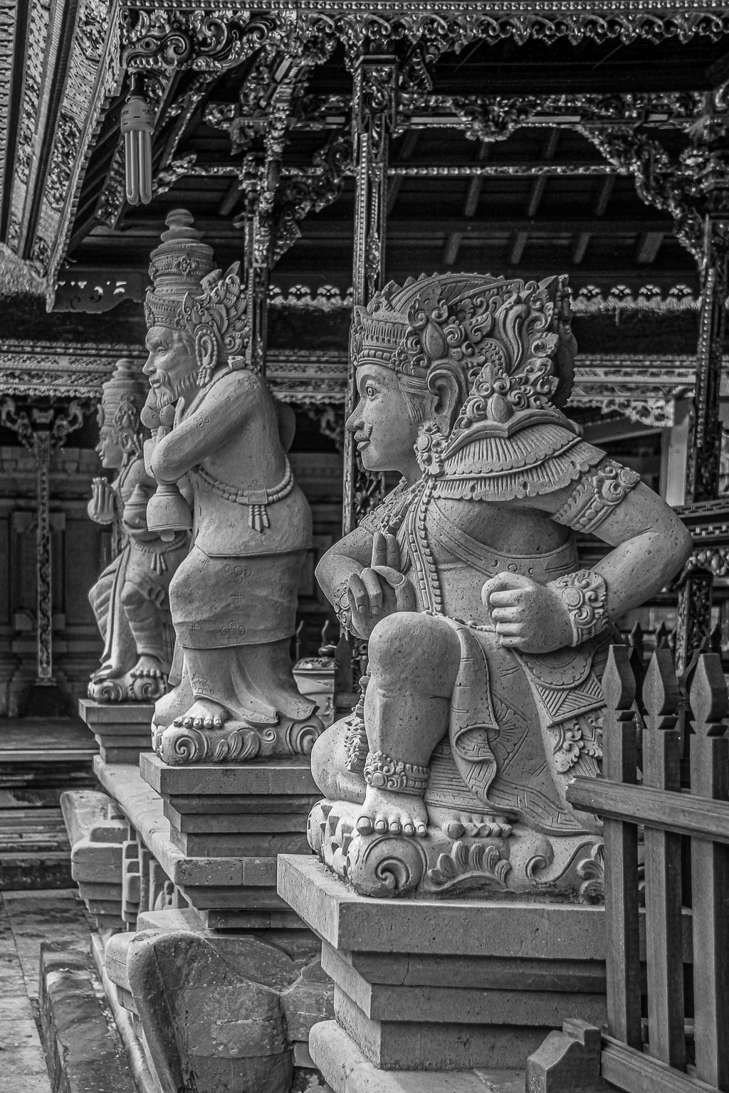 Black-and-white photo of carved temple guardian statues in a row.