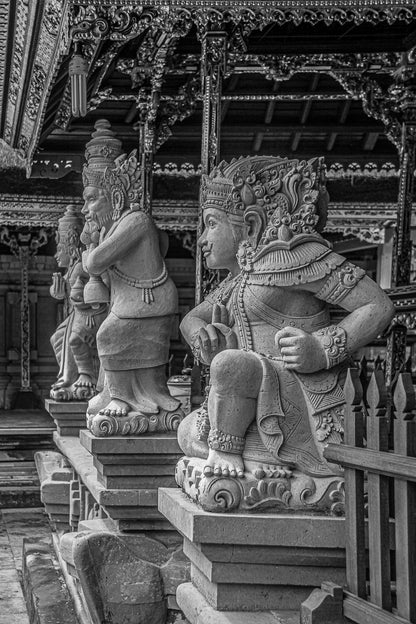 Black-and-white photo of carved temple guardian statues in a row.